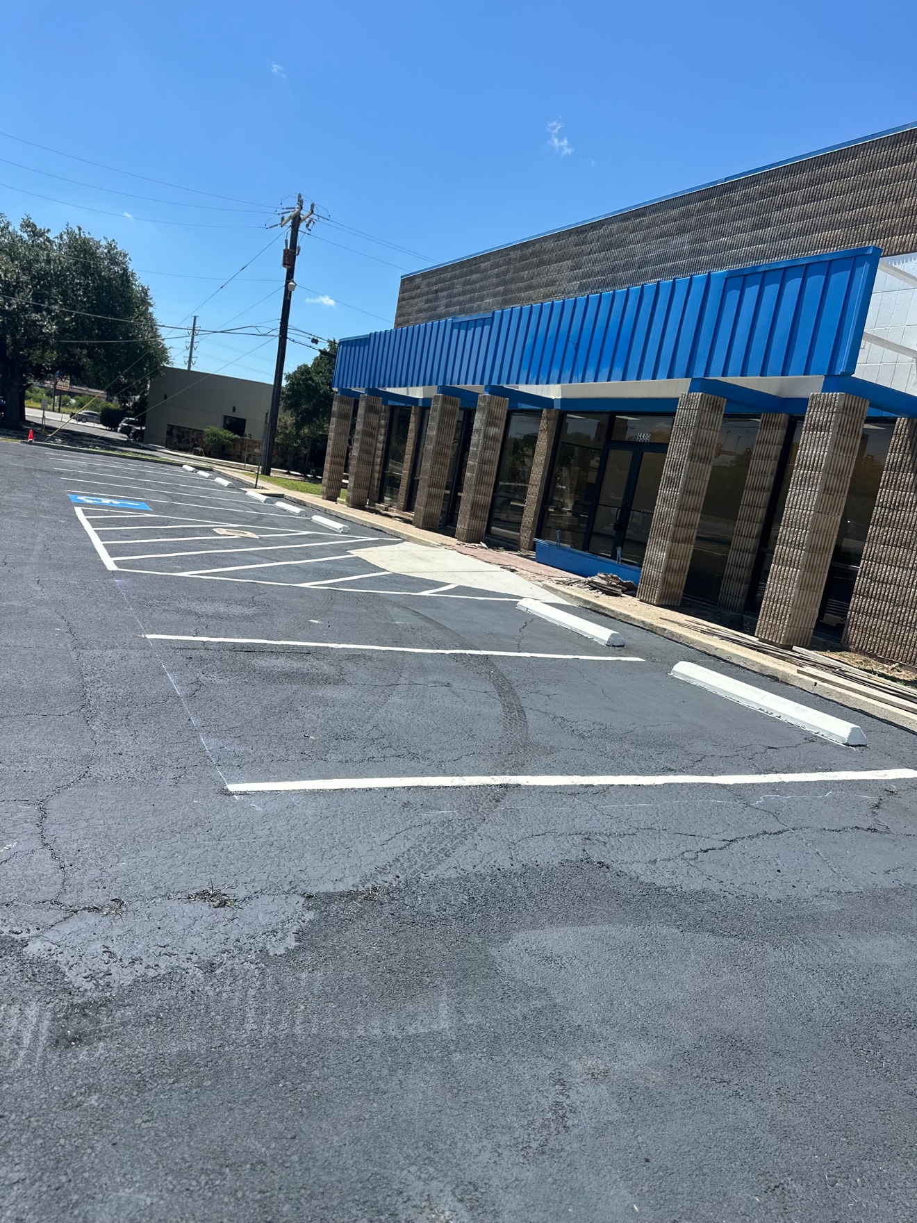Freshly coated and striped asphalt parking lot with a painted handicap space