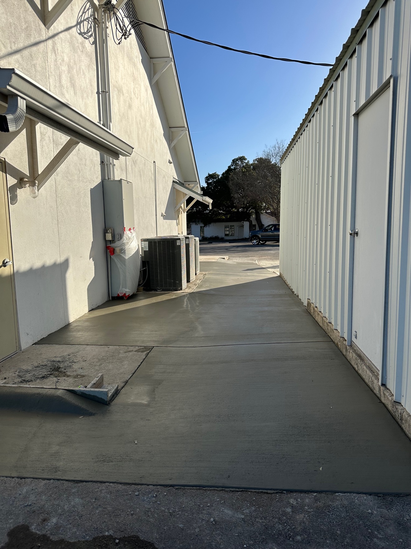 Fresh concrete walkway poured between two buildings
