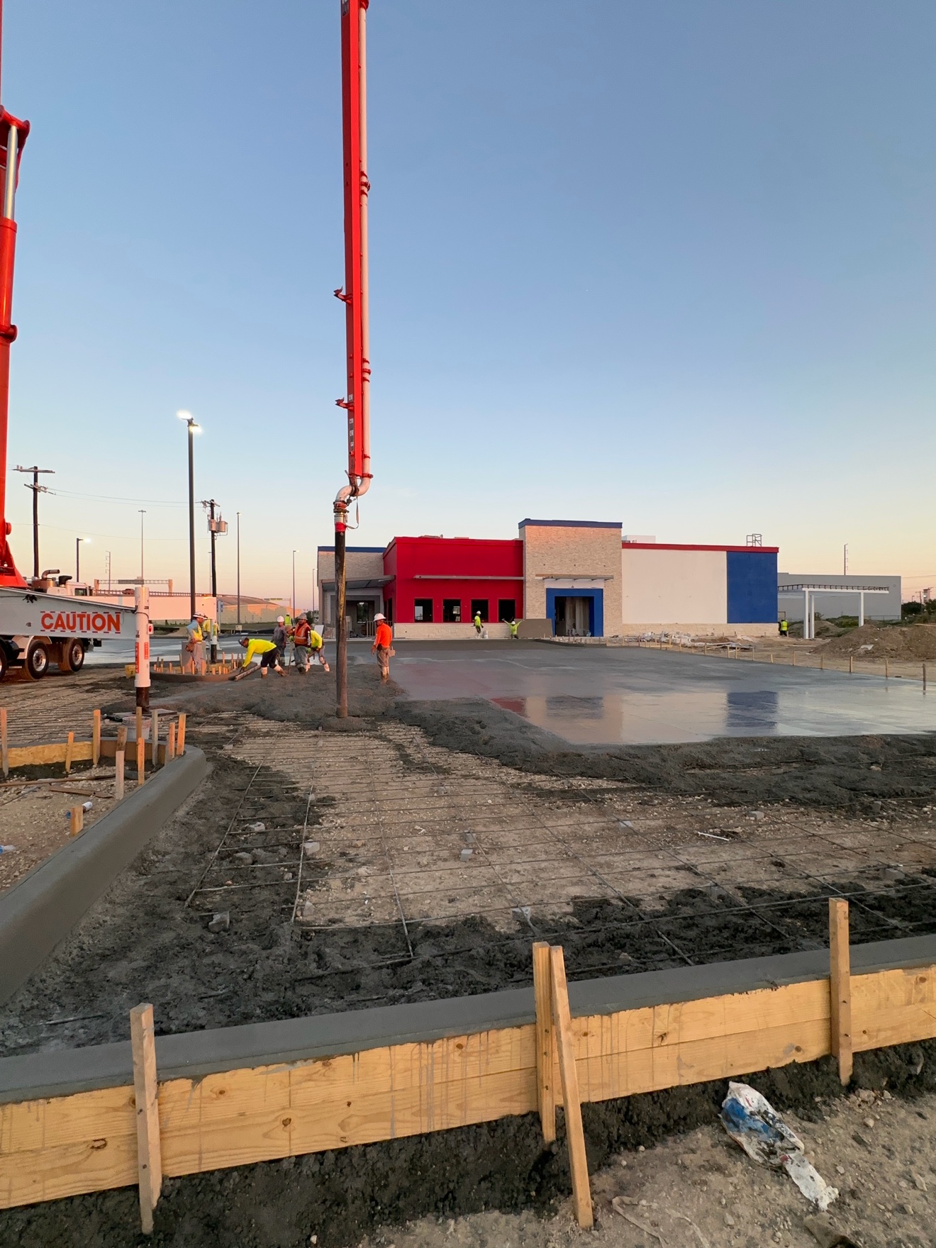 Concrete pump pour with fresh curb work and crew on site