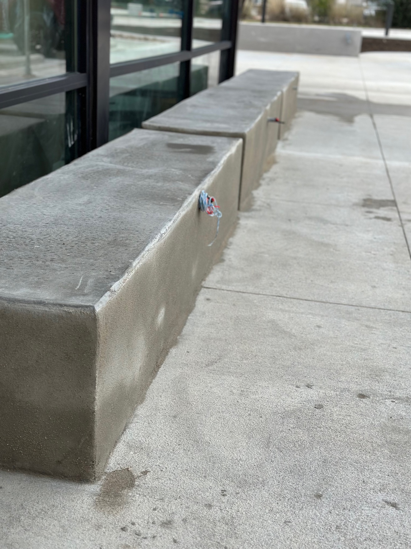 Finished concrete bench seating along a storefront