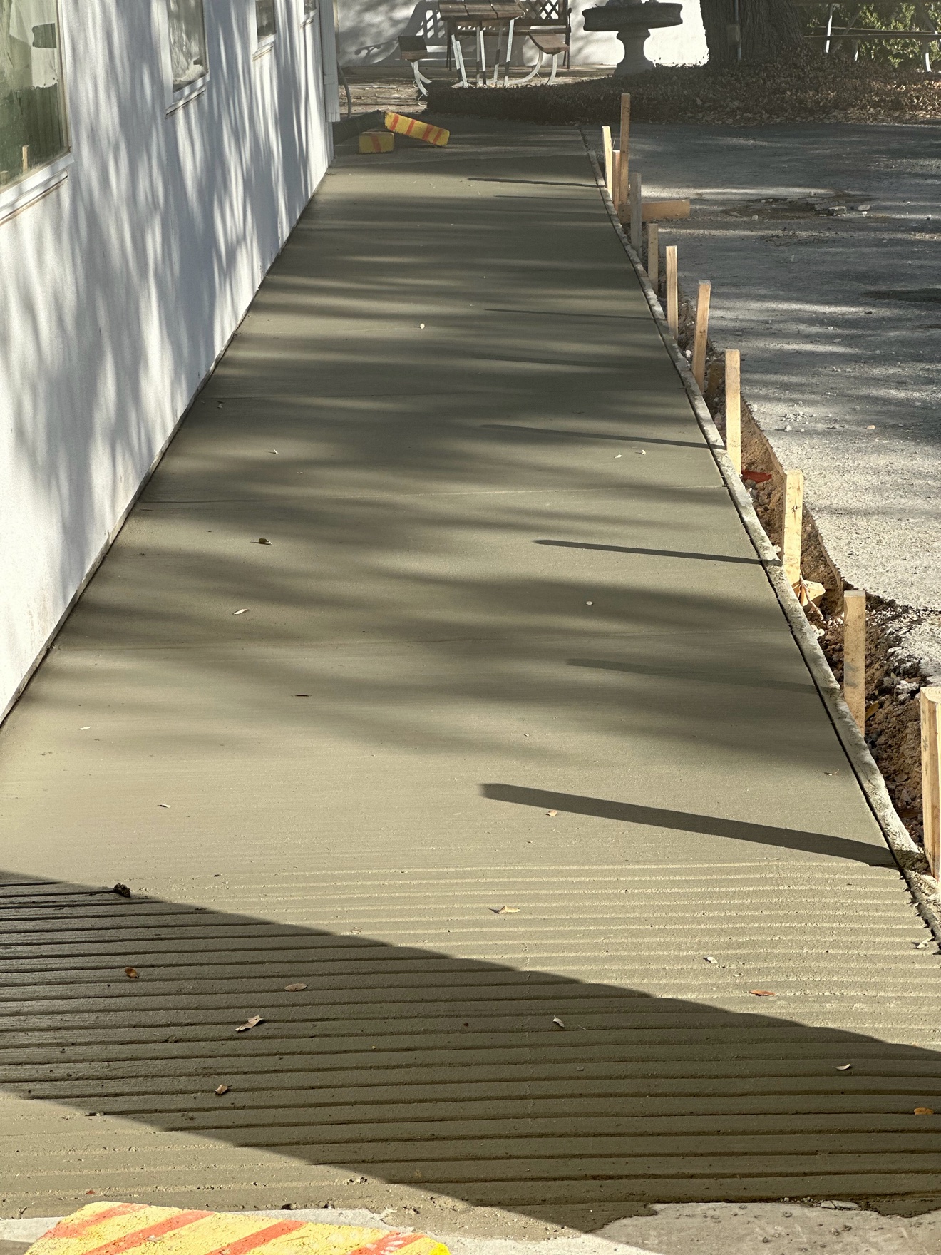 Fresh concrete walkway and ramp beside a building