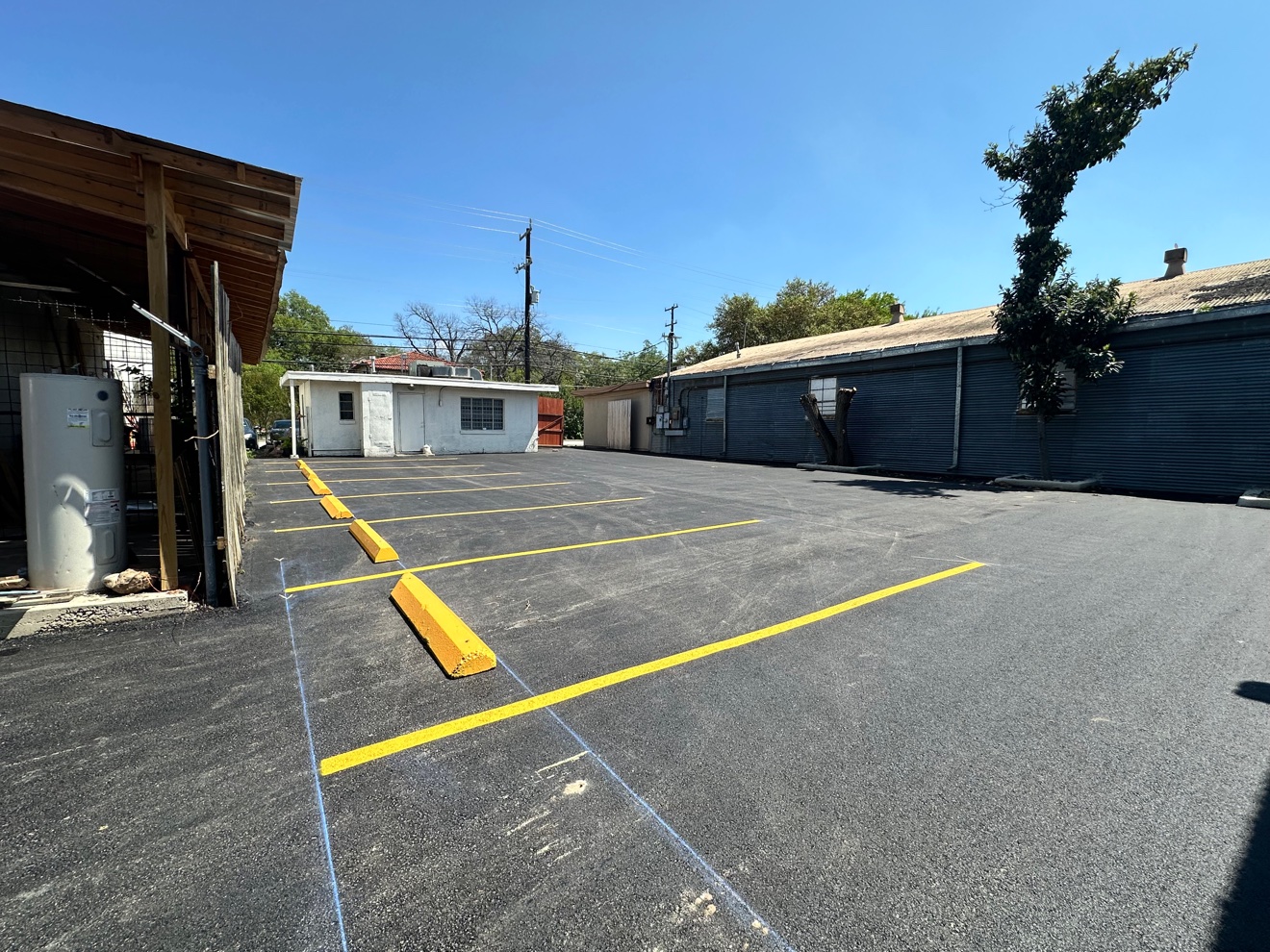 Fresh yellow parking lot striping and wheel stops viewed from the opposite side