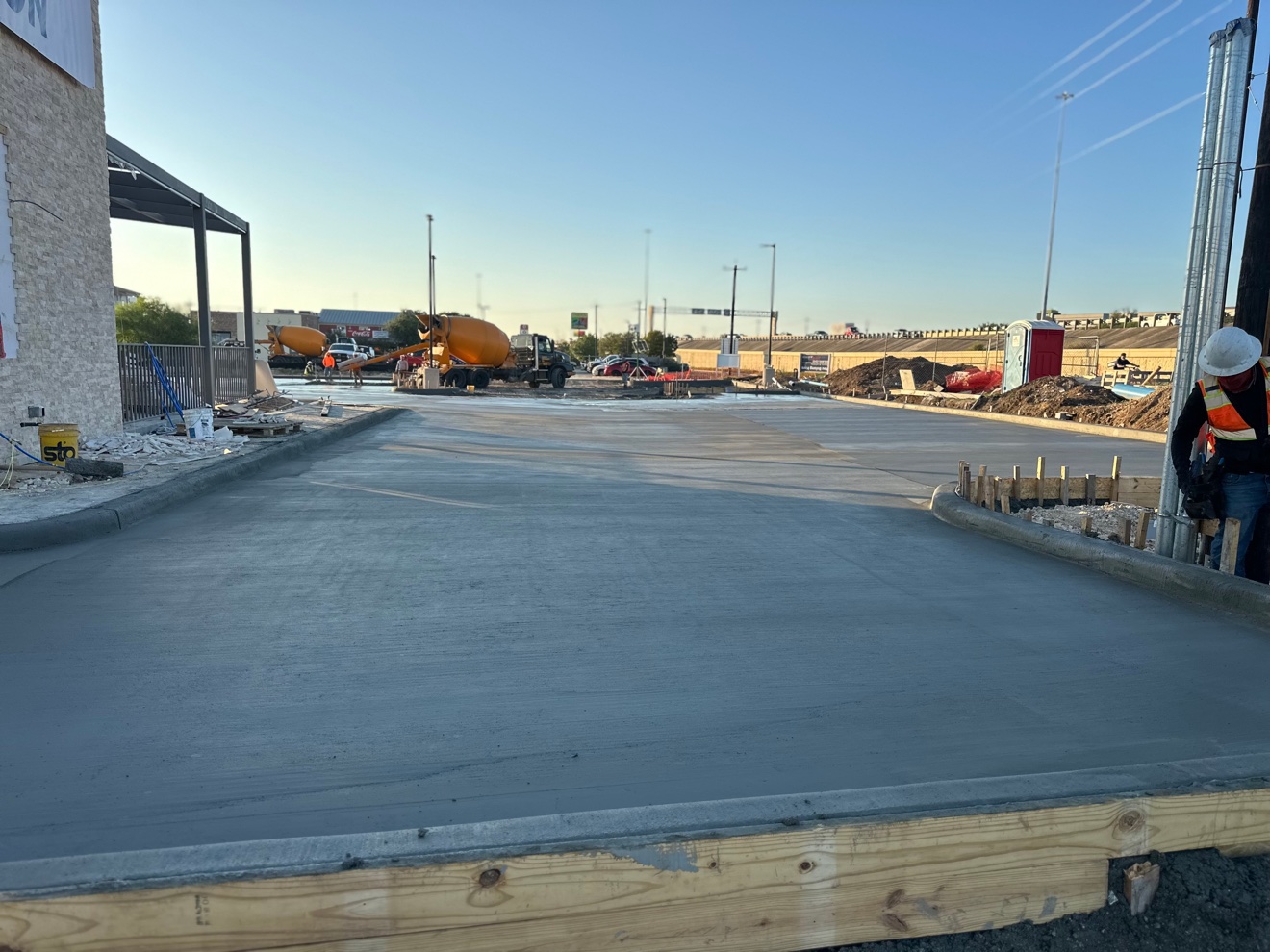 Fresh concrete parking lot pour with a mixer truck in the background
