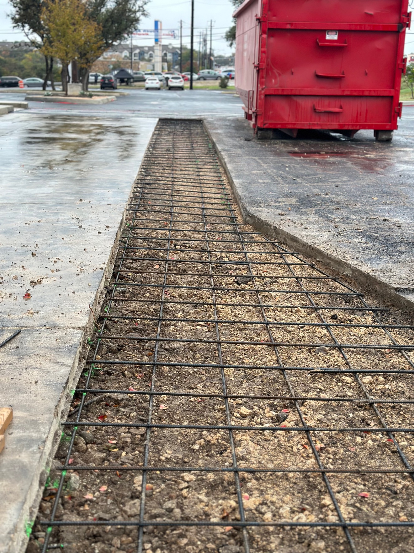 Rebar grid laid by hand in the excavated sidewalk trench