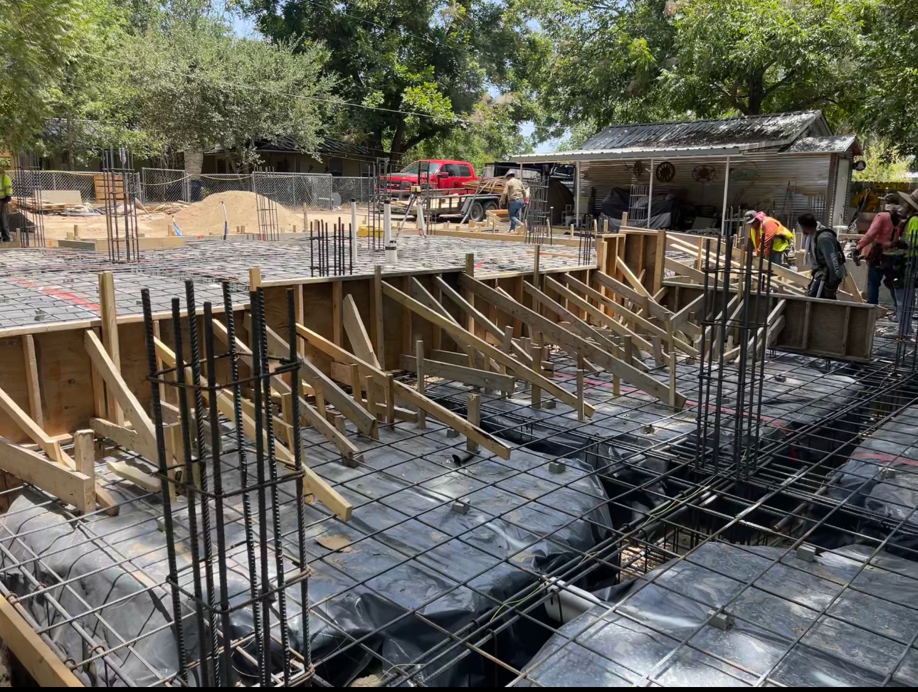 Foundation prepared with rebar grid, vapor barrier, and wood forms before the pour