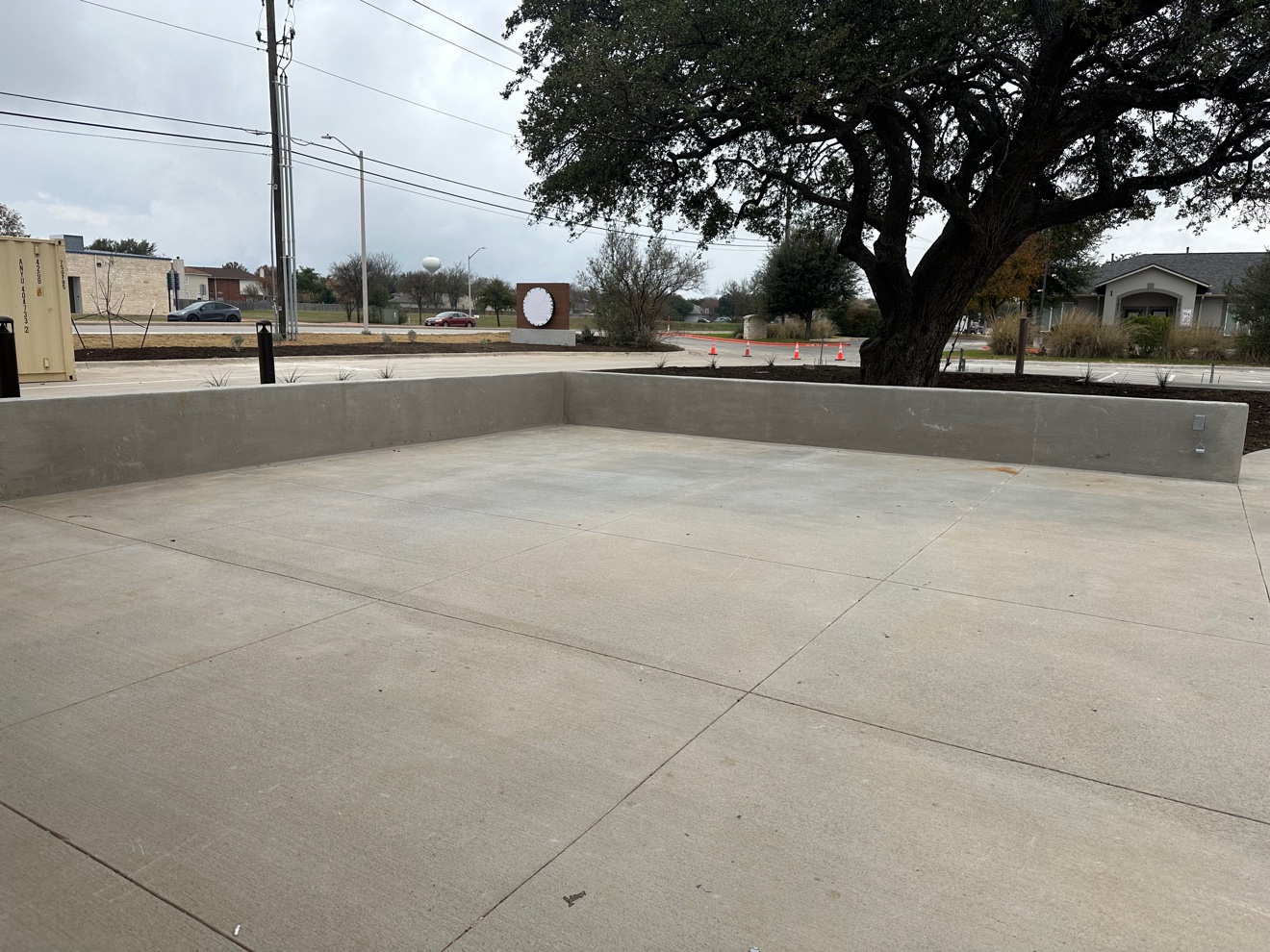 Finished concrete patio framed by low seat walls