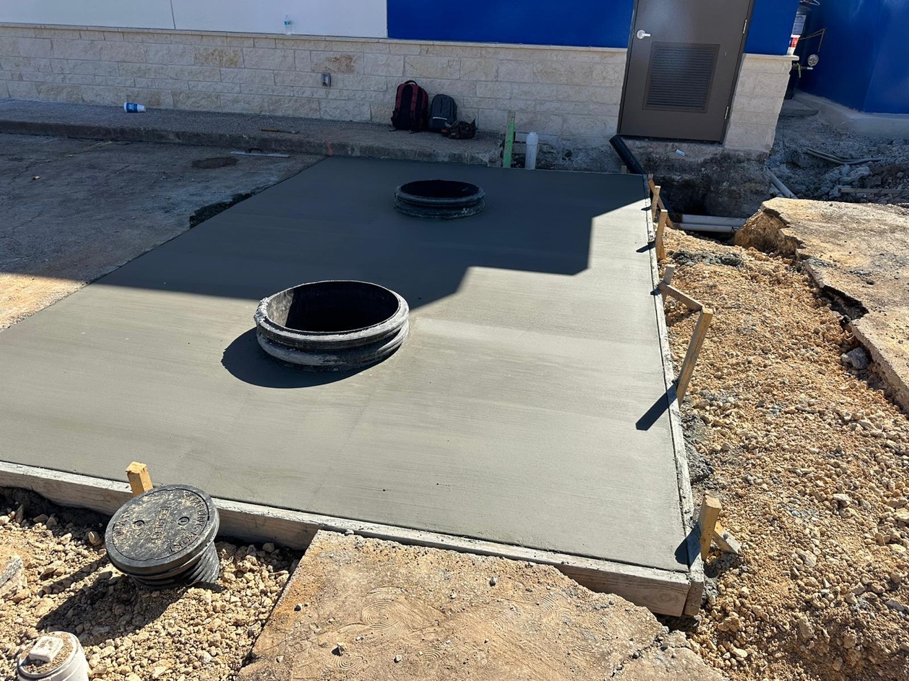 Finished concrete utility pad poured around the utility fittings