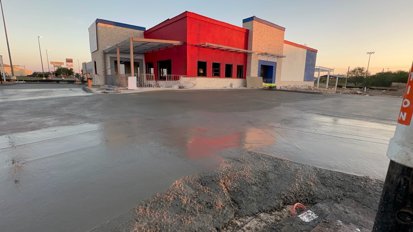Fresh concrete lot in front of a commercial building at sunset