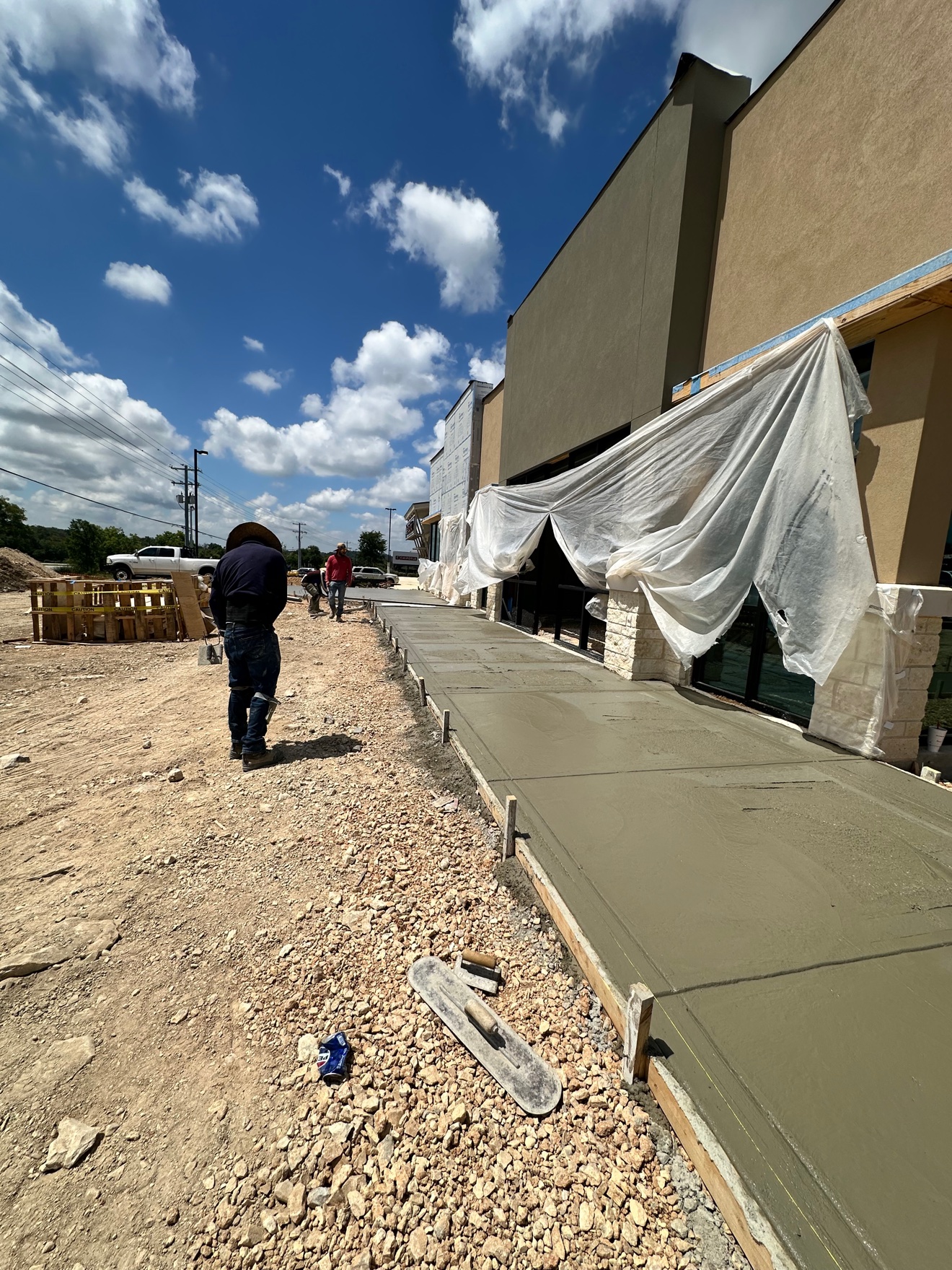 Crew finishing a fresh concrete sidewalk pour at Panera Bread